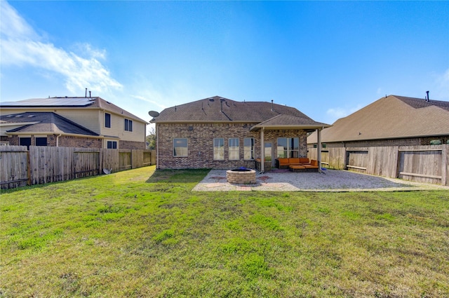 rear view of house with a patio area, a yard, and an outdoor fire pit