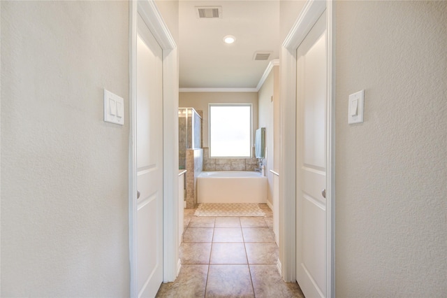 corridor with crown molding and light tile patterned floors