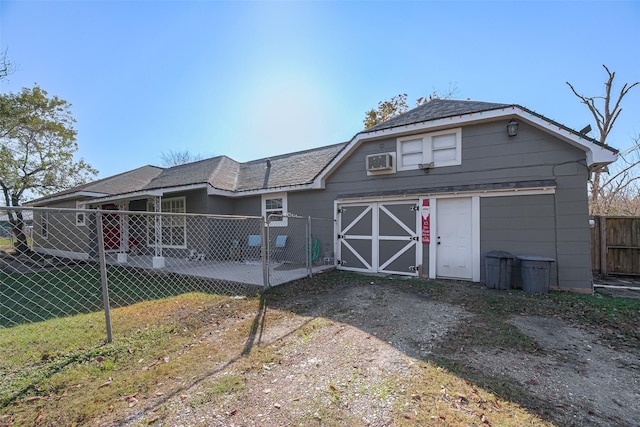 back of house with an AC wall unit and a yard