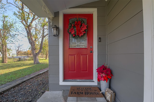 view of exterior entry featuring a lawn