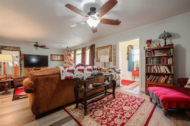 living room featuring ceiling fan, ornamental molding, and hardwood / wood-style flooring