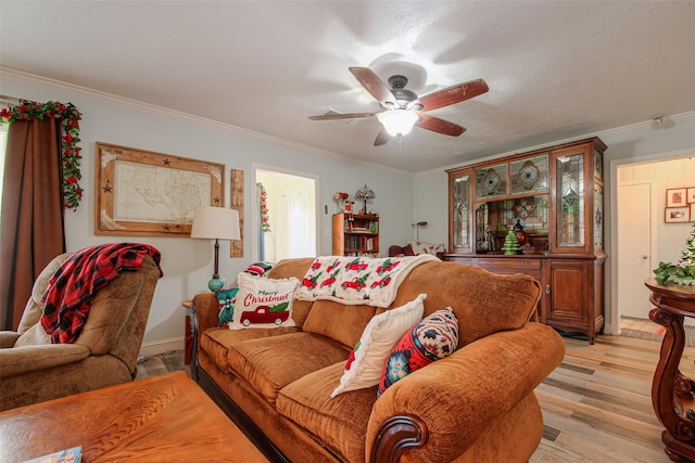 living room with light hardwood / wood-style floors, ceiling fan, and ornamental molding