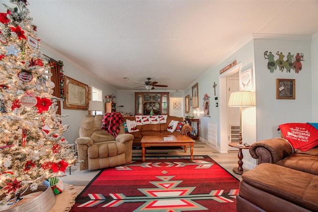 living room with light hardwood / wood-style floors, ceiling fan, and ornamental molding