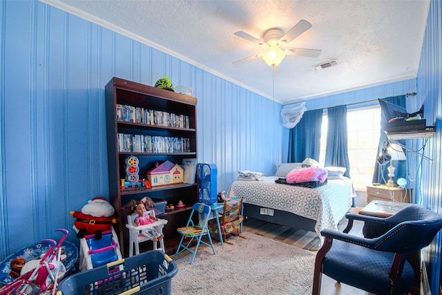 bedroom with ceiling fan, crown molding, and a textured ceiling