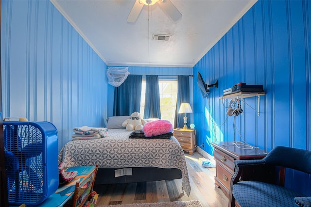 bedroom featuring hardwood / wood-style flooring, ceiling fan, and crown molding