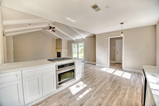 kitchen featuring decorative light fixtures, lofted ceiling with beams, light stone counters, and stainless steel appliances