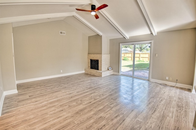 unfurnished living room with ceiling fan, a fireplace, lofted ceiling with beams, and light hardwood / wood-style flooring