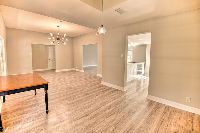 unfurnished dining area featuring light hardwood / wood-style flooring and a notable chandelier