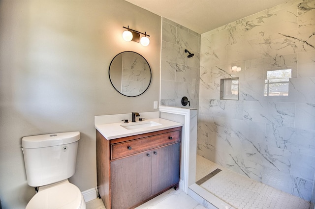 bathroom featuring tiled shower, vanity, and toilet