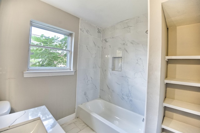 full bathroom with sink, tiled shower / bath combo, and toilet