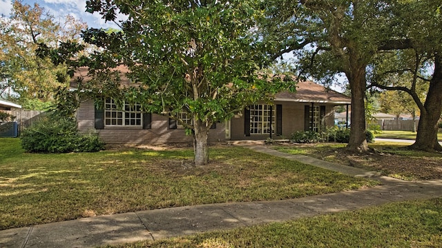 view of property hidden behind natural elements with a front lawn