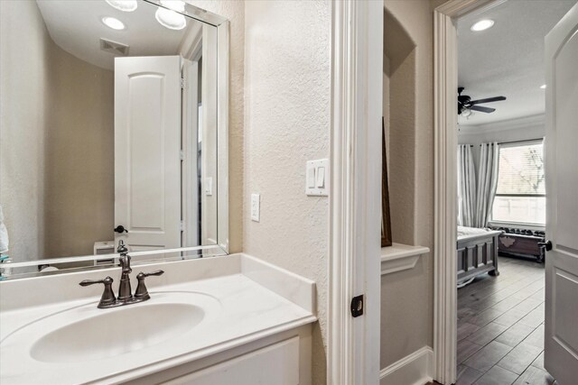 bathroom featuring vanity, ornamental molding, and ceiling fan