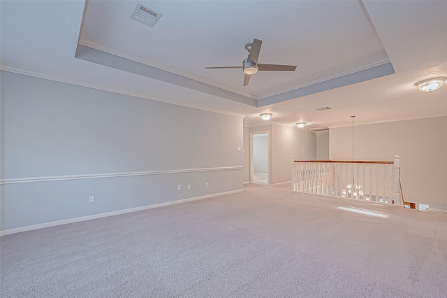 spare room featuring ceiling fan, carpet flooring, crown molding, and a tray ceiling