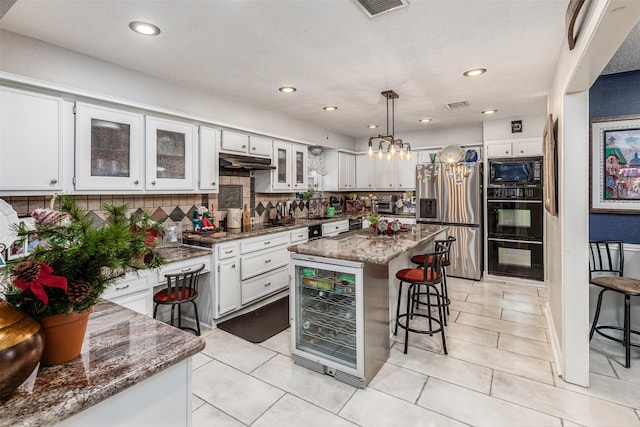 kitchen featuring wine cooler, white cabinets, black appliances, and decorative light fixtures