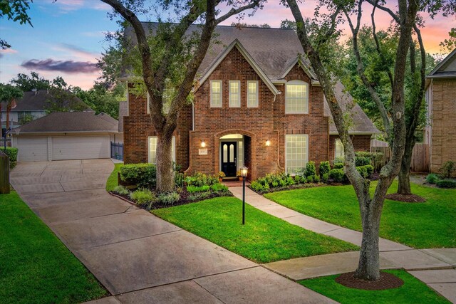 english style home with a yard and a garage