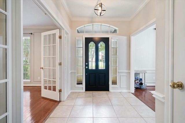 tiled foyer featuring ornamental molding