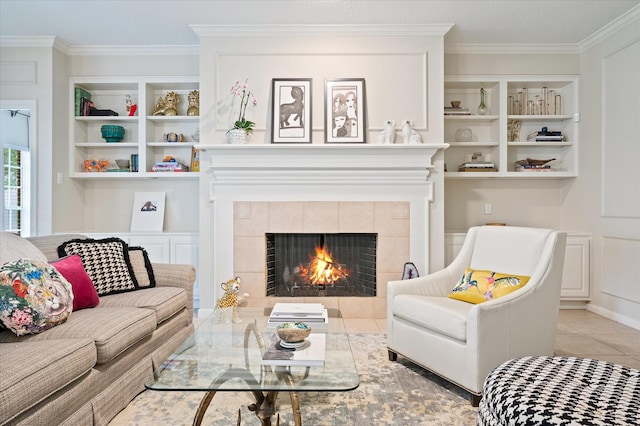 living room featuring crown molding, a tile fireplace, built in features, and light tile patterned floors