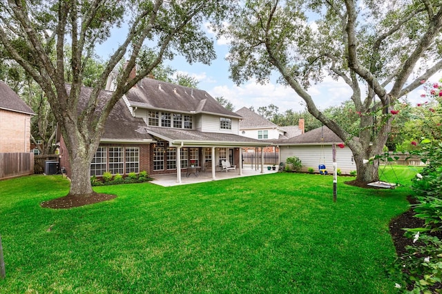 back of property with a patio area, a yard, and central AC