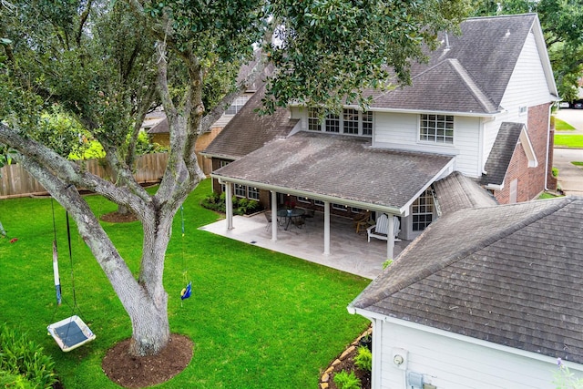 back of property with a yard and a patio area