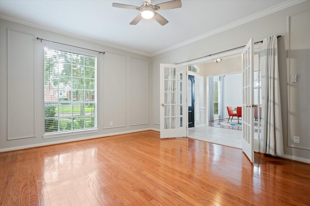 spare room featuring ceiling fan, light wood-type flooring, a wealth of natural light, and french doors