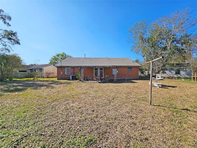 rear view of house with a lawn and central AC