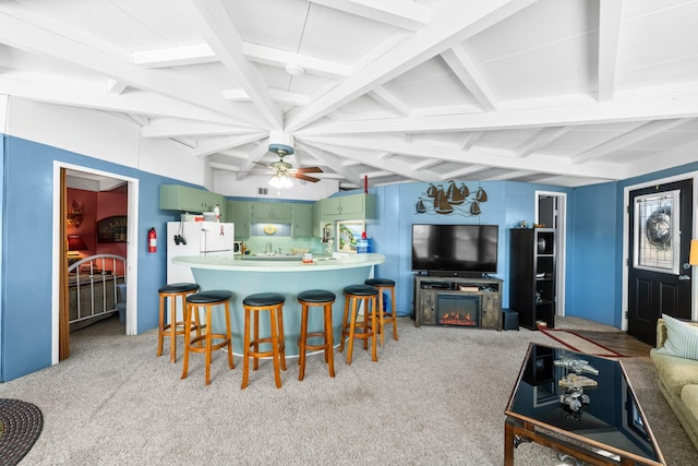 kitchen featuring ceiling fan, beamed ceiling, white refrigerator, a kitchen bar, and light carpet