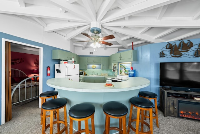 kitchen featuring carpet flooring, ceiling fan, beamed ceiling, white fridge, and green cabinets