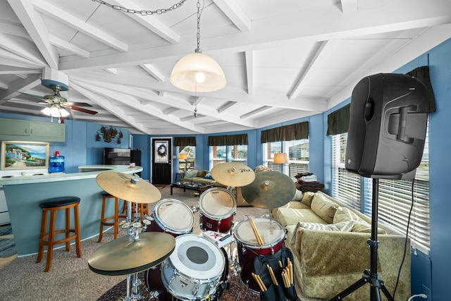 dining room with beamed ceiling, carpet floors, and ceiling fan