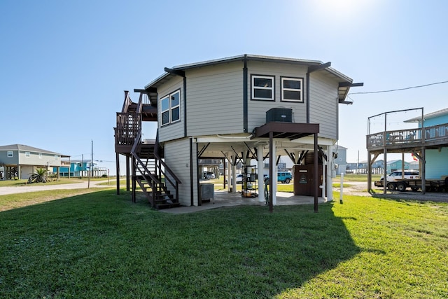 back of house with a lawn, a deck, and a carport