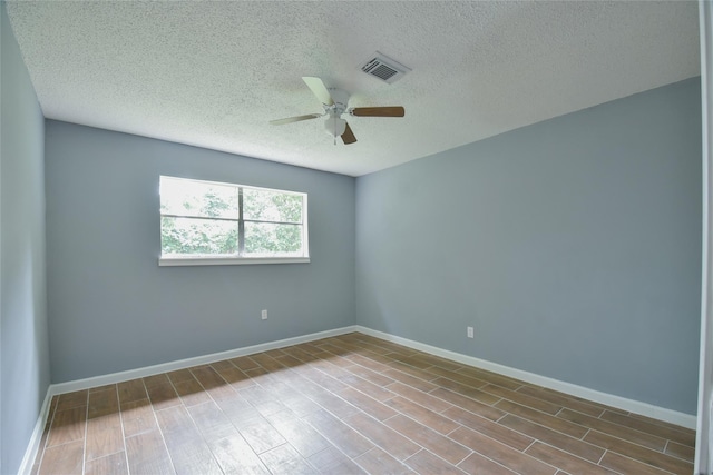 empty room featuring a textured ceiling, light hardwood / wood-style floors, and ceiling fan