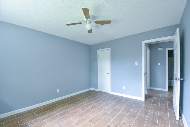 empty room featuring ceiling fan and a textured ceiling