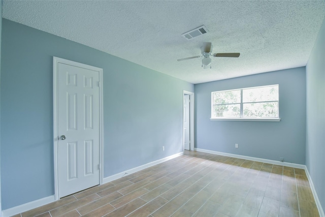 unfurnished room featuring ceiling fan and a textured ceiling