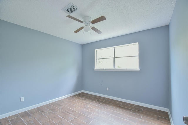 unfurnished room with ceiling fan and a textured ceiling