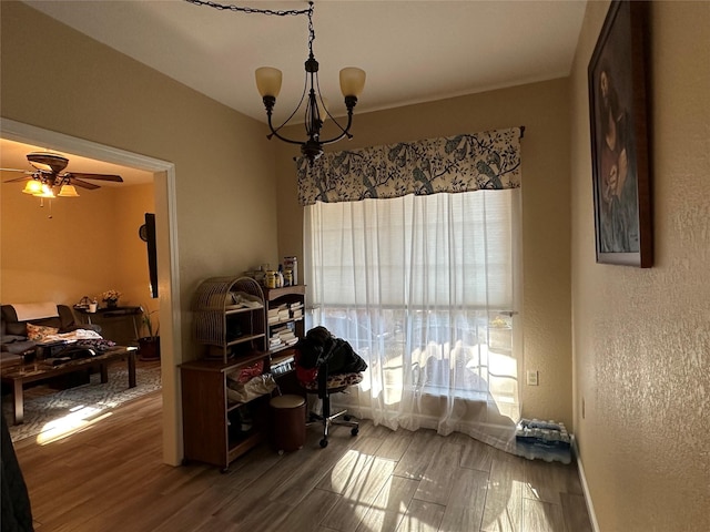 office featuring hardwood / wood-style floors and ceiling fan with notable chandelier