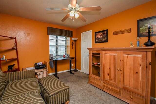 sitting room featuring baseboards, a ceiling fan, and light colored carpet