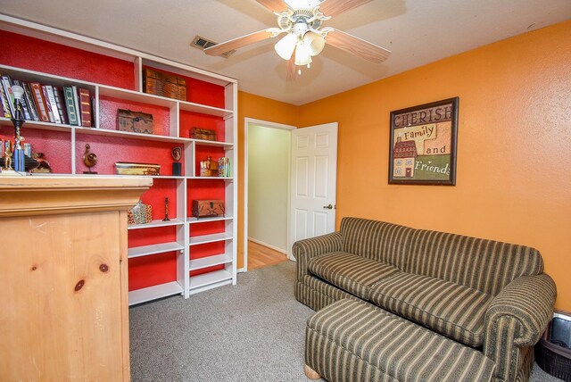 sitting room featuring ceiling fan, visible vents, and carpet flooring