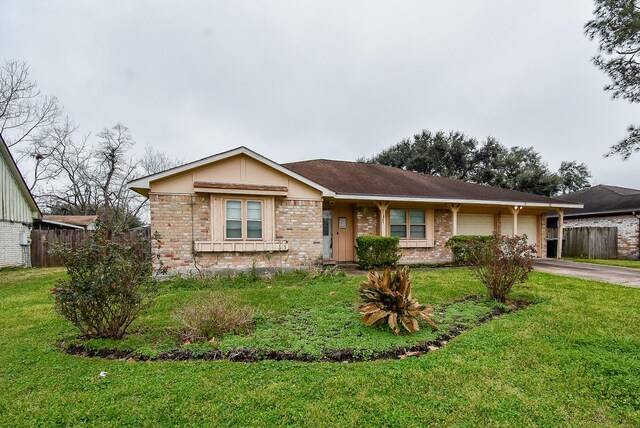 single story home featuring a garage, driveway, brick siding, and a front yard