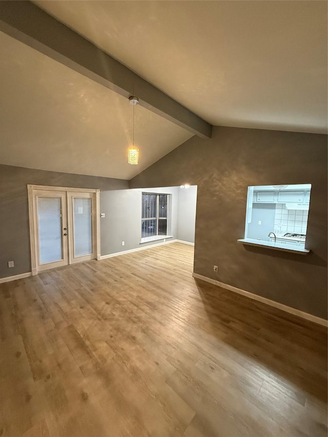 unfurnished living room featuring lofted ceiling with beams and wood-type flooring