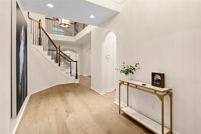 foyer featuring a chandelier, light hardwood / wood-style floors, and a high ceiling