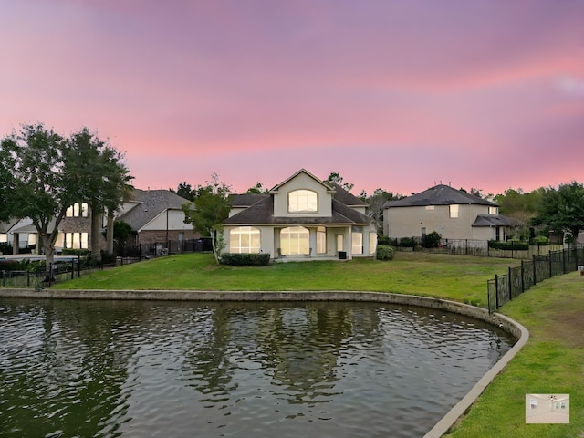 exterior space featuring a lawn and a water view