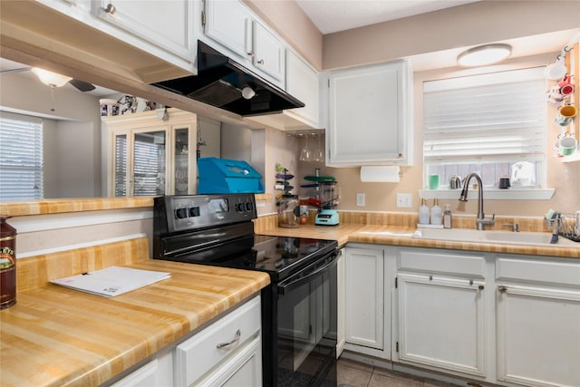 kitchen with black range with electric stovetop, white cabinetry, sink, and light tile patterned floors