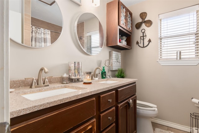 bathroom featuring vanity, a healthy amount of sunlight, and toilet