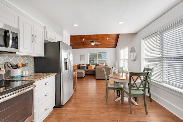 kitchen featuring light stone countertops, ceiling fan, stainless steel appliances, tasteful backsplash, and white cabinets