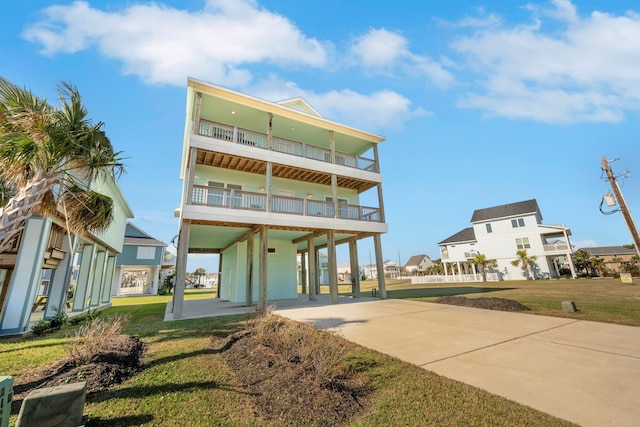 back of house featuring a yard, a balcony, and a carport