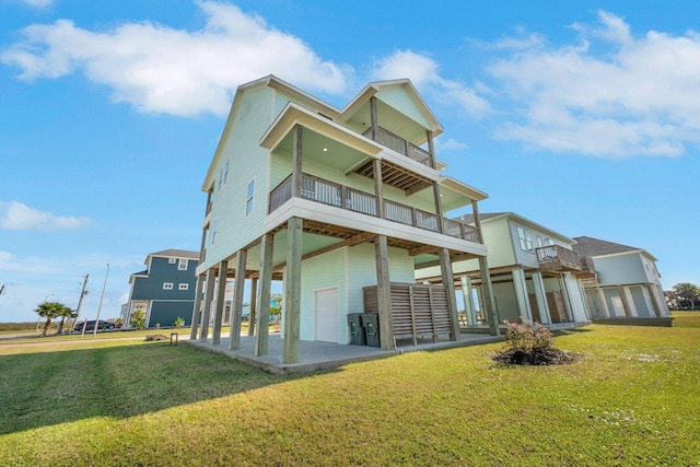 back of property with a lawn, a balcony, and a garage