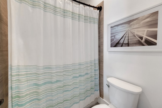 bathroom featuring a shower with shower curtain and toilet