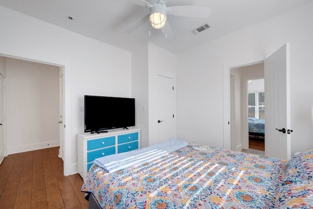 bedroom with dark hardwood / wood-style flooring and ceiling fan