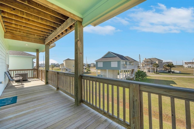 wooden terrace featuring central AC unit and a lawn