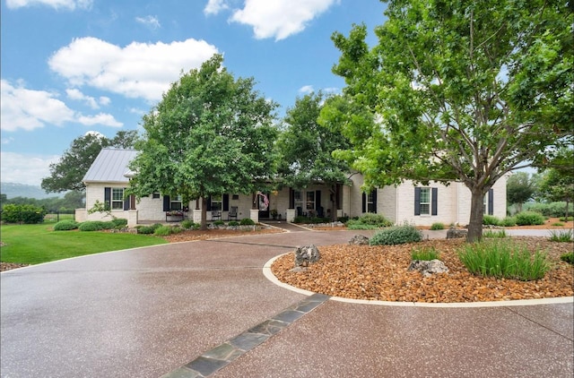 view of property hidden behind natural elements featuring a front lawn