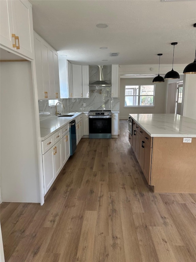 kitchen with stainless steel electric stove, light stone countertops, white cabinets, and wall chimney exhaust hood